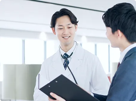 医師に社員が最新情報を提供している画像