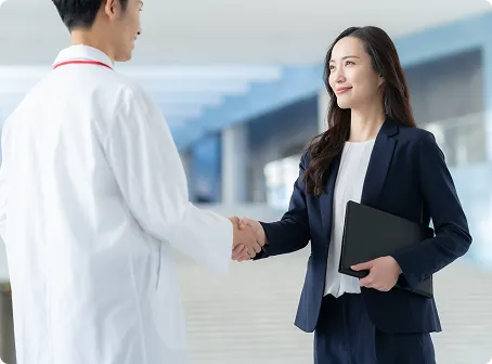 医師と女性社員が握手している画像